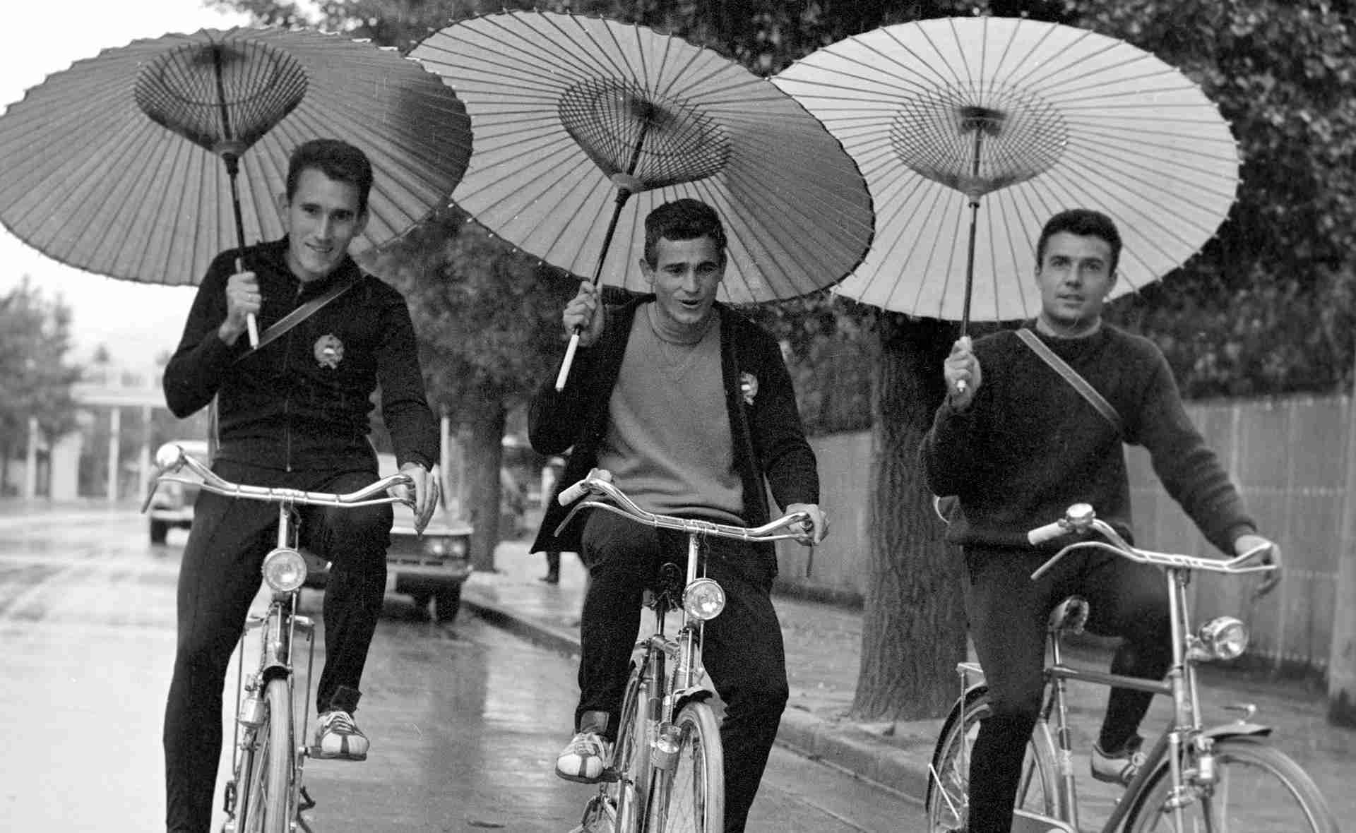 選手村で和傘をさしながら自転車に乗る三人の選手
（左から順に）マホー・ラースロー (Mahó László)、メーサーロシュ・アンドラーシュ (Mészáros András)、シュタームス・フェレンツ (Stámusz Ferenc) (©MTI/OL)
